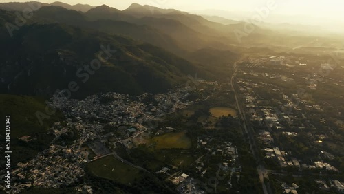 Drone flights forward tilting camera up and revealing amazing hill during sunrise, beautiful mountain siluetes. Filmed in Margalla Hills Islamabad photo