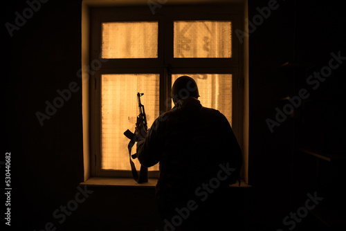 Conceptual photo of war between Russia and Ukraine. Ukraine and Russia flags on windowsill at night. Old creepy room with window.