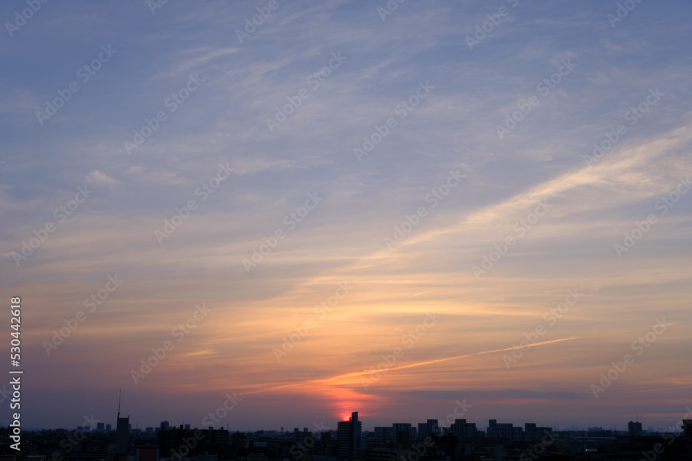 兵庫県神戸市東灘区の高層マンションの上層階からの夜明け。大阪生駒山から太陽が昇り、あたりはオレンジ色に染まり、ビル群がシルエットで浮かぶ