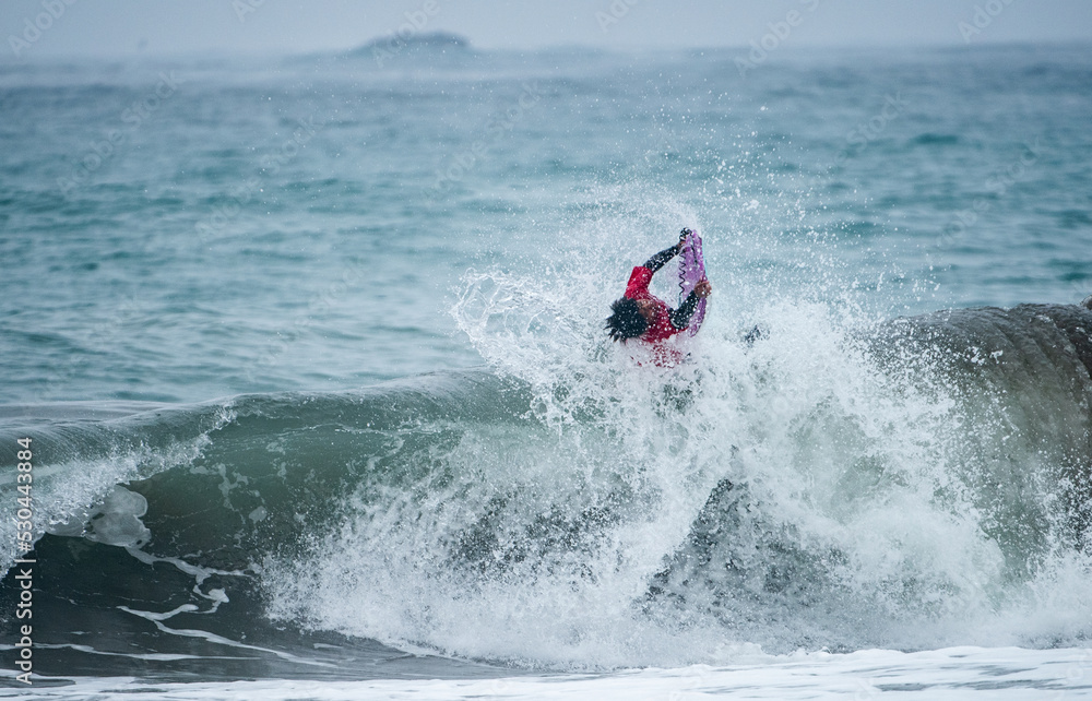 Bodyboarder in action on the ocean waves on a sunny day.