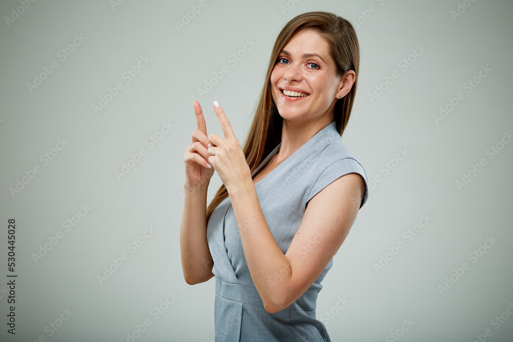 Smiling business woman pointing fingers up. isolated portrait on gray. Smiling business woman pointing fingers up. isolated portrait on gray.