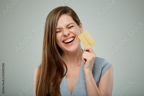 Laughing business woman with eyes closed holding credit card isolated portrait.