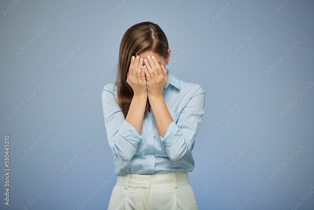 Woman hide her face with hands. isolated female portrait on blue. Woman hide her face with hands. isolated female portrait on blue.