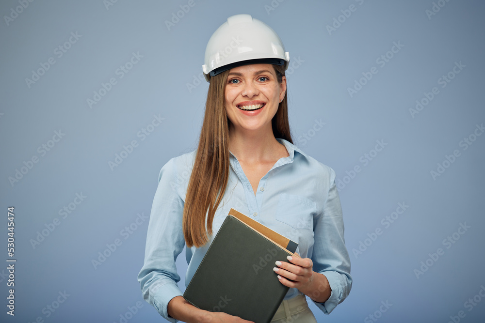 University engineering student wearing protective industrial helmet with a book in her hand. Isolated female portrait.. Isolated female portrait. University engineering student wearing protective industrial helmet with a book in her hand. Isolated female portrait.. Isolated female portrait.
