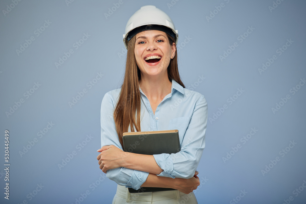 University engineering student wearing protective industrial helmet with a book in her hand. Isolated female portrait.. Isolated female portrait.