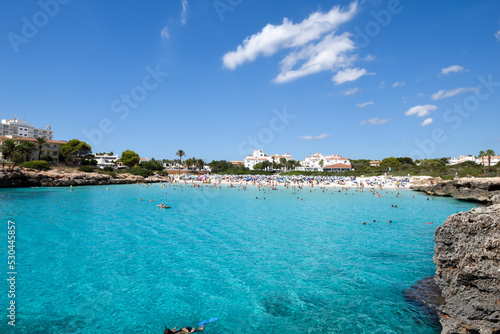 Beach resort in summer with clear blue sea water and sky people are relaxing in the sun