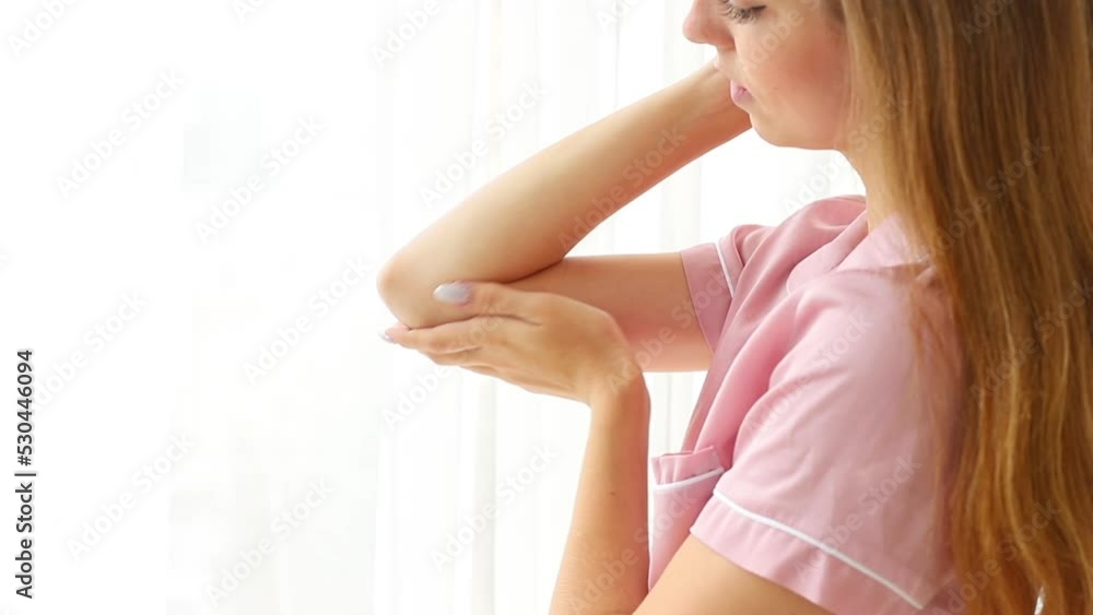 woman applying moisturizer on dry skin of elbow woman applying moisturizer on dry skin of elbow