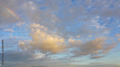 Картината върху платно Late afternoon storm clouds break up revealing blue sky, white clouds and partial rainbow