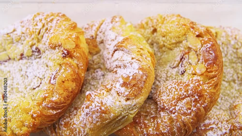Macro closeup zoom zooming in shot of almond filled filling danishes dessert food in plastic tray container showing texture detail isolated against white background kitchen table Macro closeup zoom zooming in shot of almond filled filling danishes dessert food in plastic tray container showing texture detail isolated against white background kitchen table