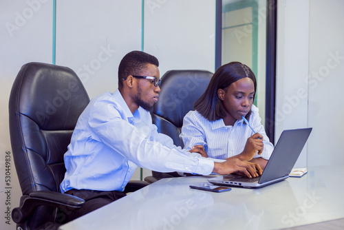 African businessman and woman in a conference room with a laptop