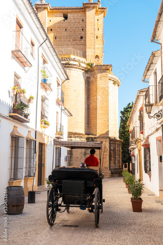Carriage with tourists next to the Church of Santa Maria la Mayor in the historic center of Ronda, Malaga © unai