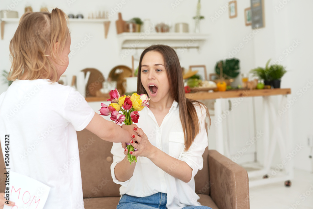 A cute little girl gives flowers and congratulates her mother, happy mother's day or March 8. A cute little girl gives flowers and congratulates her mother, happy mother's day or March 8.