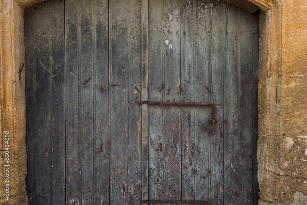 Old wooden door with a rusty lock. Close-up. Front view. Old wooden door with a rusty lock. Close-up. Front view.