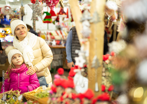 Smiling woman with small daughter in Christmas market. High quality photo