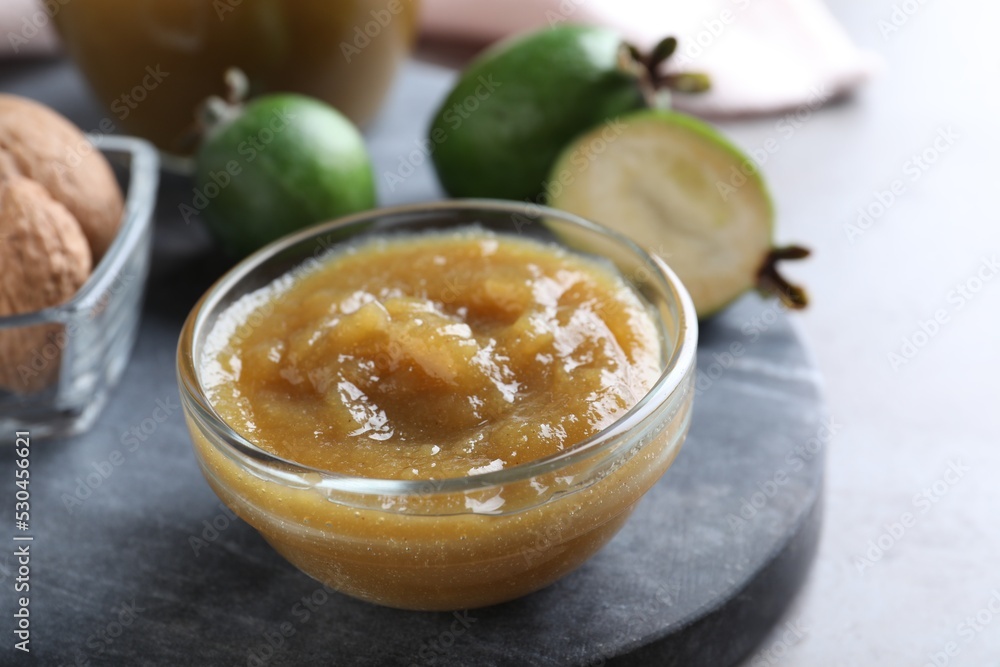 Feijoa jam in glass bowl on grey table, closeup Feijoa jam in glass bowl on grey table, closeup