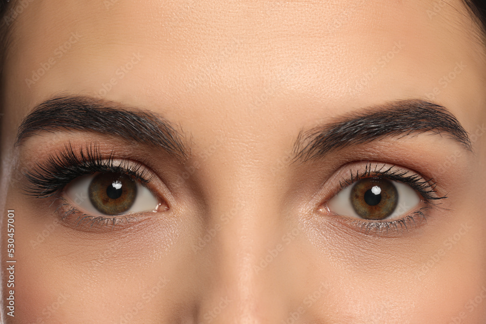 Beautiful young woman showing extended and ordinary eyelashes, closeup Beautiful young woman showing extended and ordinary eyelashes, closeup
