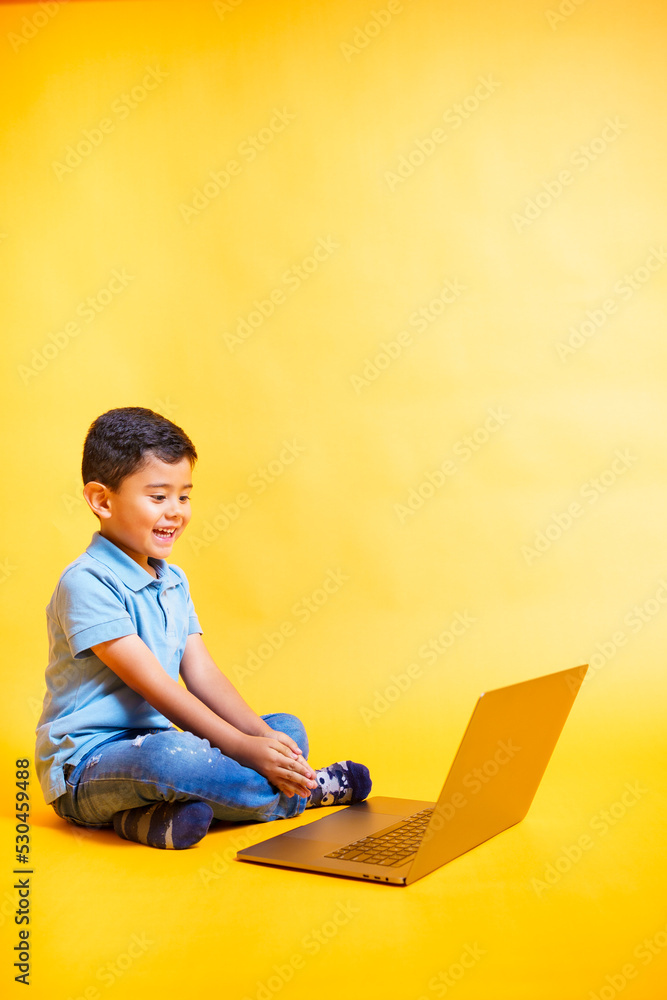 smiling boy looking at laptop smiling boy looking at laptop