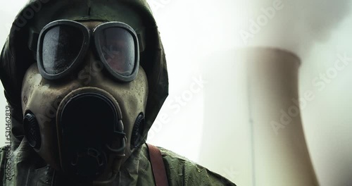 Portrait of a person in a chemical protective suit and mask with a radiation measuring device. photo