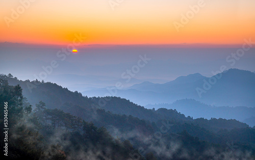 Sunrise, sunset and landscape sky in outdoor beautiful. Beautiful sunrise, mist and colorful sky over the hills in Chiang Dao, Chiang Mai - Thailand.