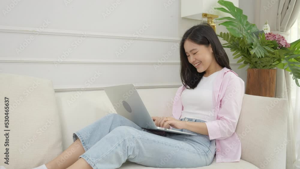 Young asian business woman work from home with laptop computer online to internet on sofa in living room, freelance girl using notebook sitting on couch with comfort and relax, lifestyles concept. Young asian business woman work from home with laptop computer online to internet on sofa in living room, freelance girl using notebook sitting on couch with comfort and relax, lifestyles concept.