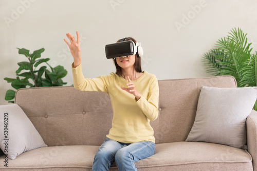 Leisure activities concept, Young woman touching the air to experience the virtual with glasses VR