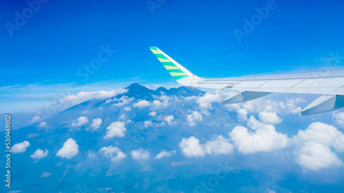 airplane wings over the air against the background of blue sky and mountains