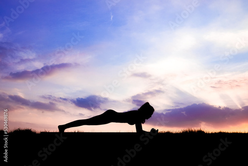 Fototapeta Naklejka Na Ścianę i Meble -  The slender girl is doing a yoga warm-up exercise outdoors