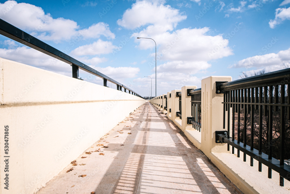 Fototapeta premium a low angle bridge with a bright sky and clouds. 