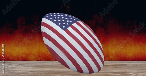 Composition of rugby ball decorated with the flag of usa on black background