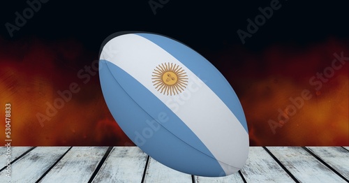 Composition of rugby ball decorated with the flag of argentina on black background