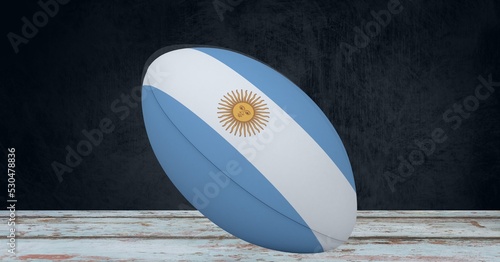 Composition of rugby ball decorated with the flag of argentina on black background
