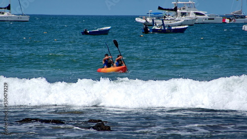 Kayaker in the water, off the beach, in Tamarindo, Costa Rica