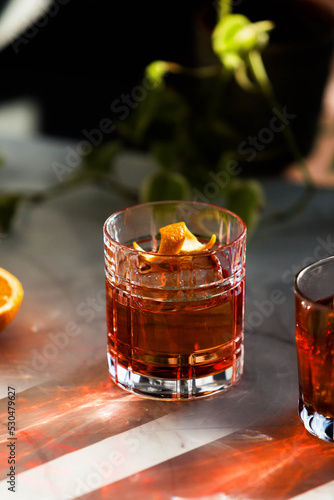 Obraz na płótnie Photo composition of two Negroni cocktail glass with sun light and shadow and or