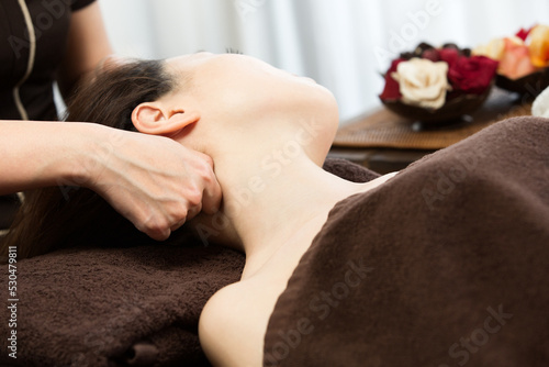 女性は首のマッサージを受けている。