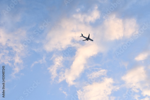 Silueta de avion de pasajeros con cielo con nubes luminosas en el atardecer