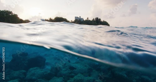 Split view of the tropical sea and island during sunset in the Maldives photo