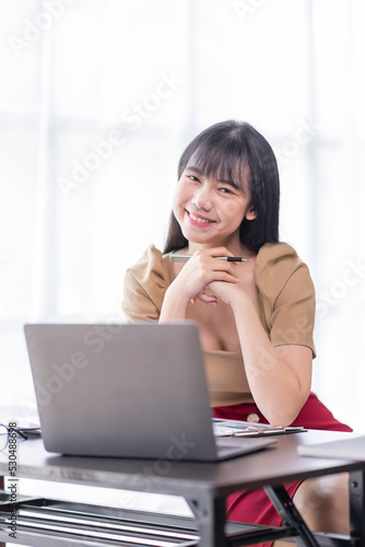 Asian Businesswoman Using laptop computer and working at workplace with calculator document on desk, planning analyzing the financial report, business plan investment, finance analysis concept.