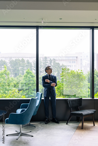 オフィスで外を眺めるエグゼクティブ男性