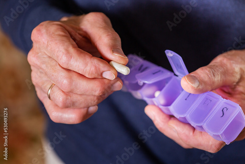 Senior man taking medicine, pills, supplement, closeup of hands
