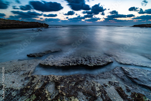 water flowing around rock textures in the beach Habonim Israel photo