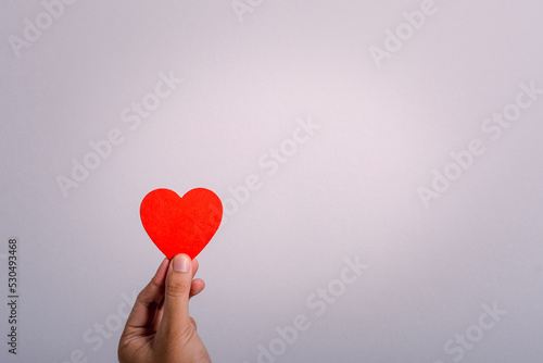 hand holding red heart with copy space for text. Express love during valentine's day. Health and care comcept.