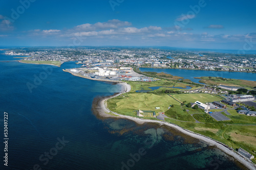 Aerial view on Galway city, Ireland on a warm sunny day. Blue cloudy sky and water of the ocean. Popular tourist town, business hub and educational center with rich history.