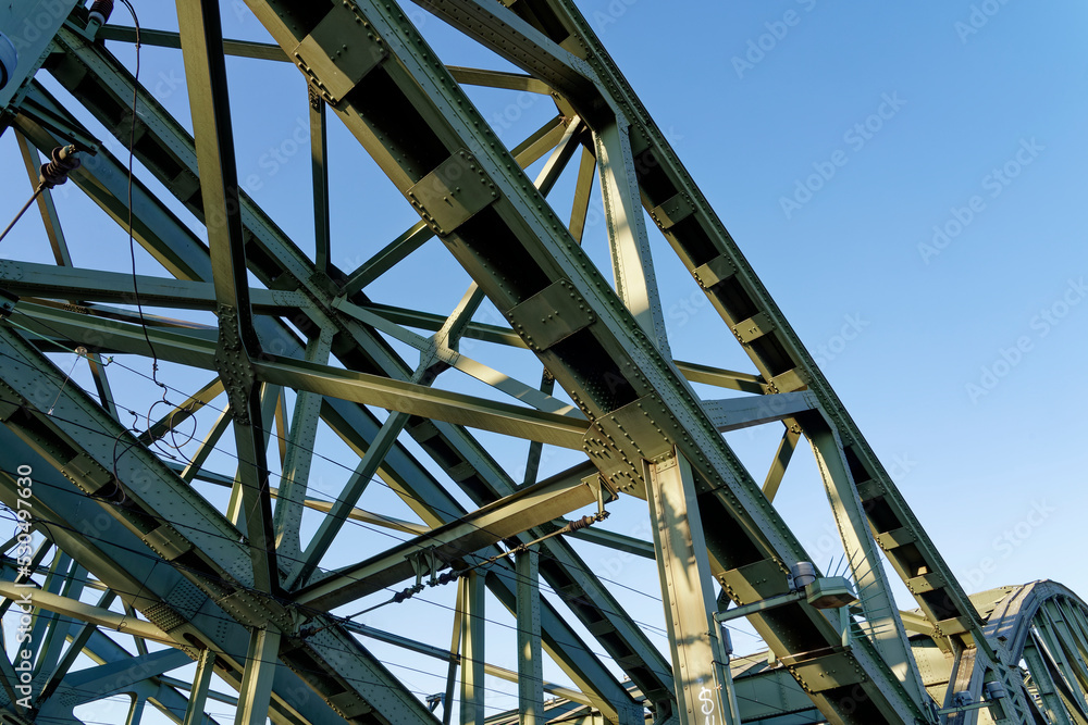 Heavy construction, bridge structure made of heavy steel girders riveted together, photographed from bottom to top.