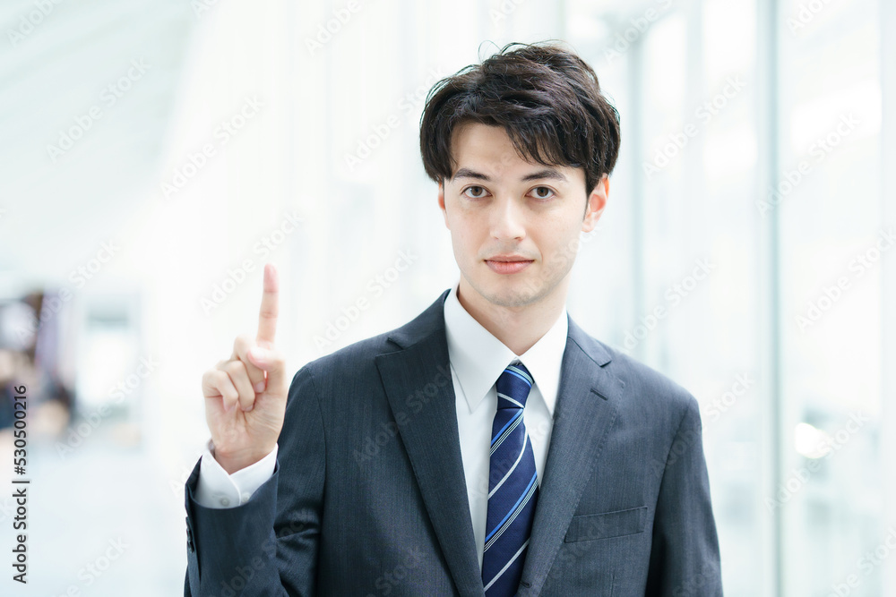 人差し指を立てるポーズをするビジネスマン 人差し指を立てるポーズをするビジネスマン
