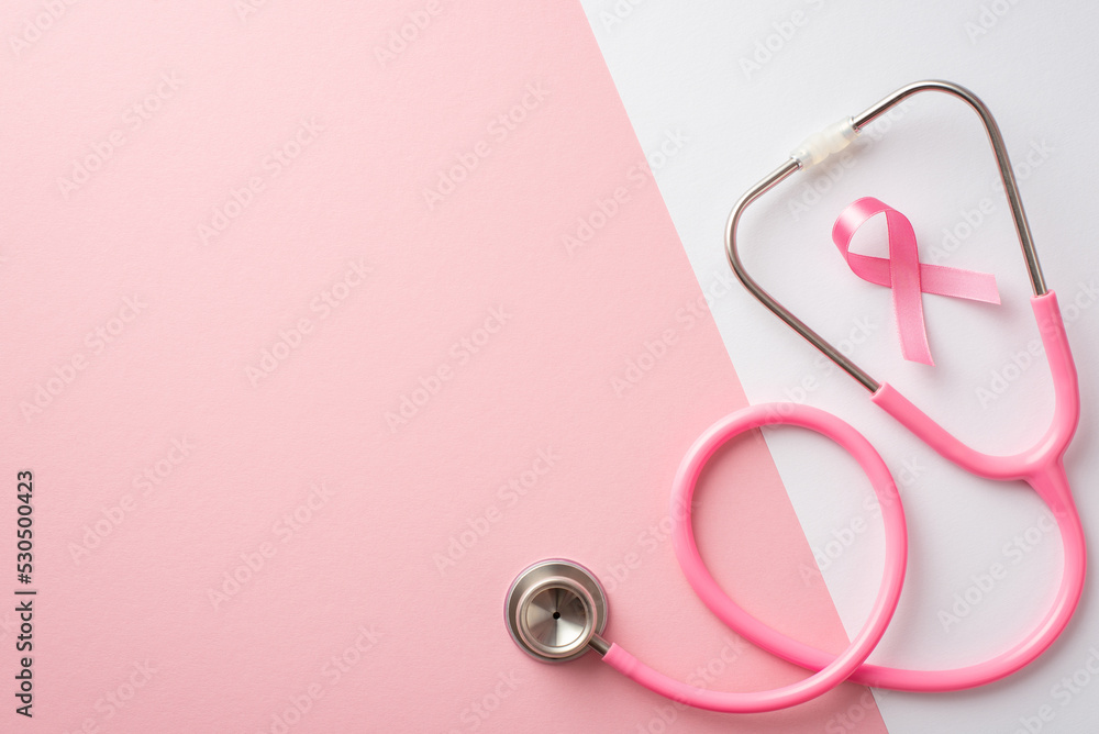 Fototapeta premium Breast cancer awareness concept. Top view photo of pink silk ribbon and stethoscope on bicolor pastel pink and white background with copyspace