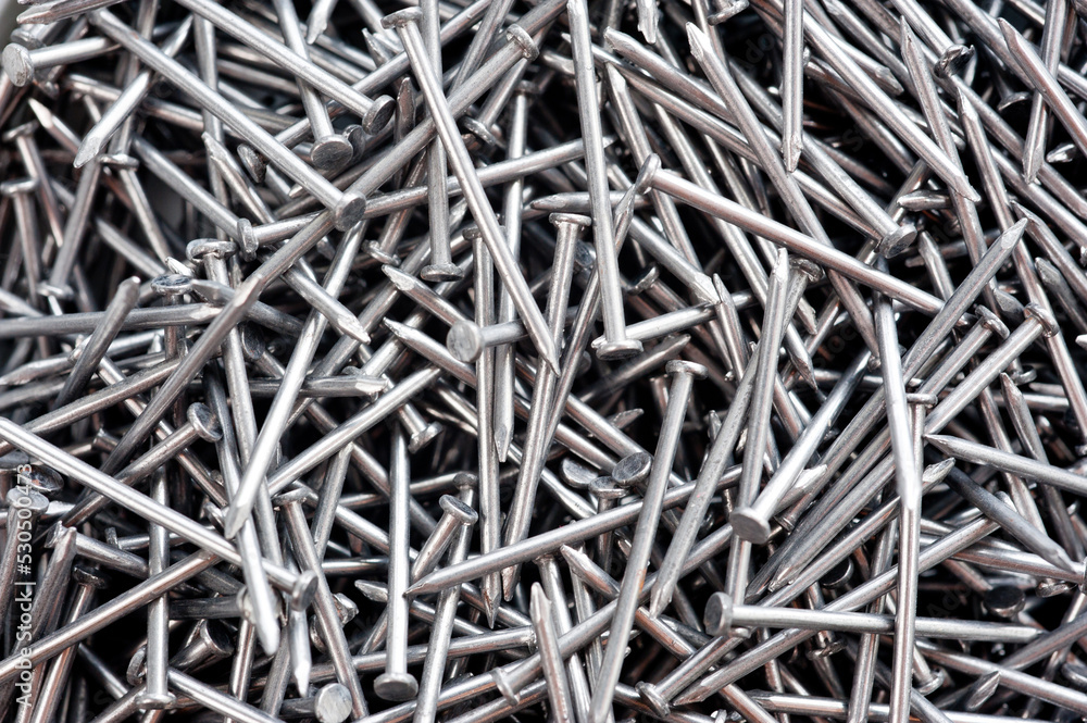 Small thin metal nails, hardware, lying in a round container. Small thin metal nails, hardware, lying in a round container.