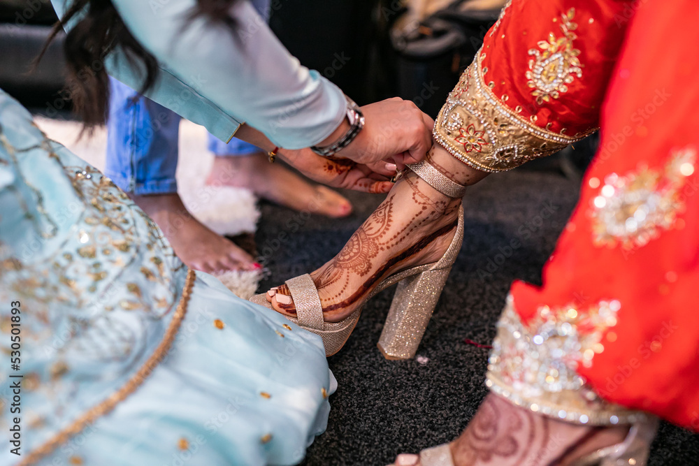 Indian Punjabi bride's wearing her wedding shoes close up