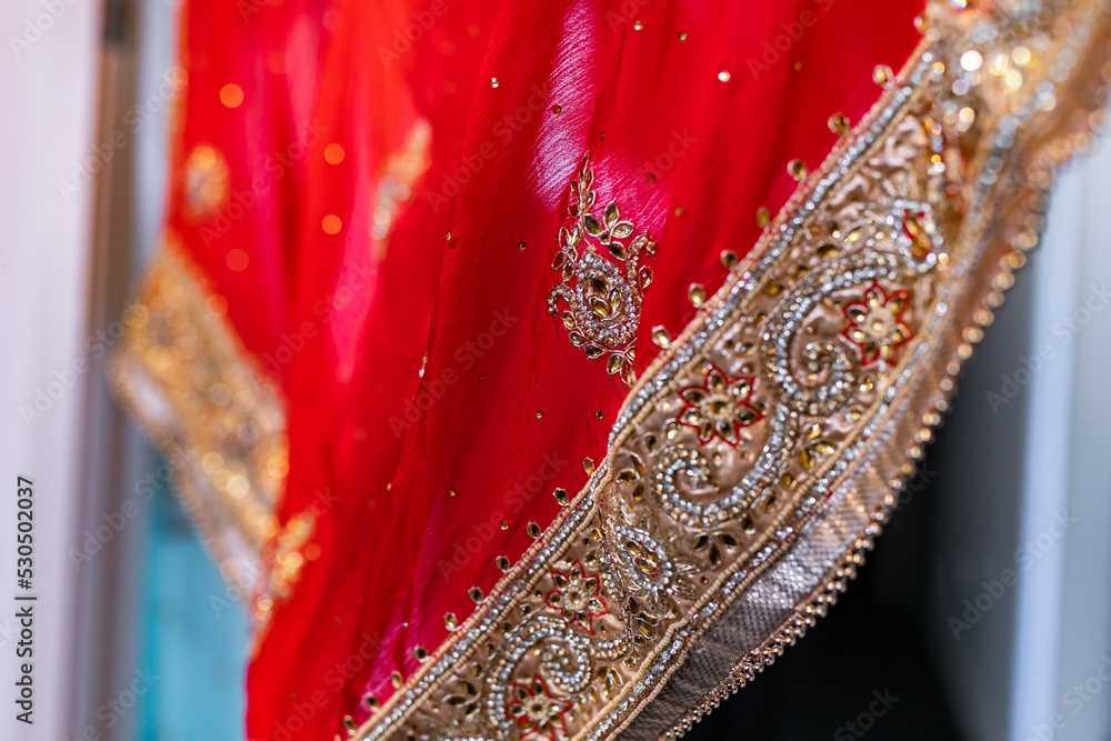 Indian Punjabi bride's red wedding outfit veil, textile, fabric and pattern close up