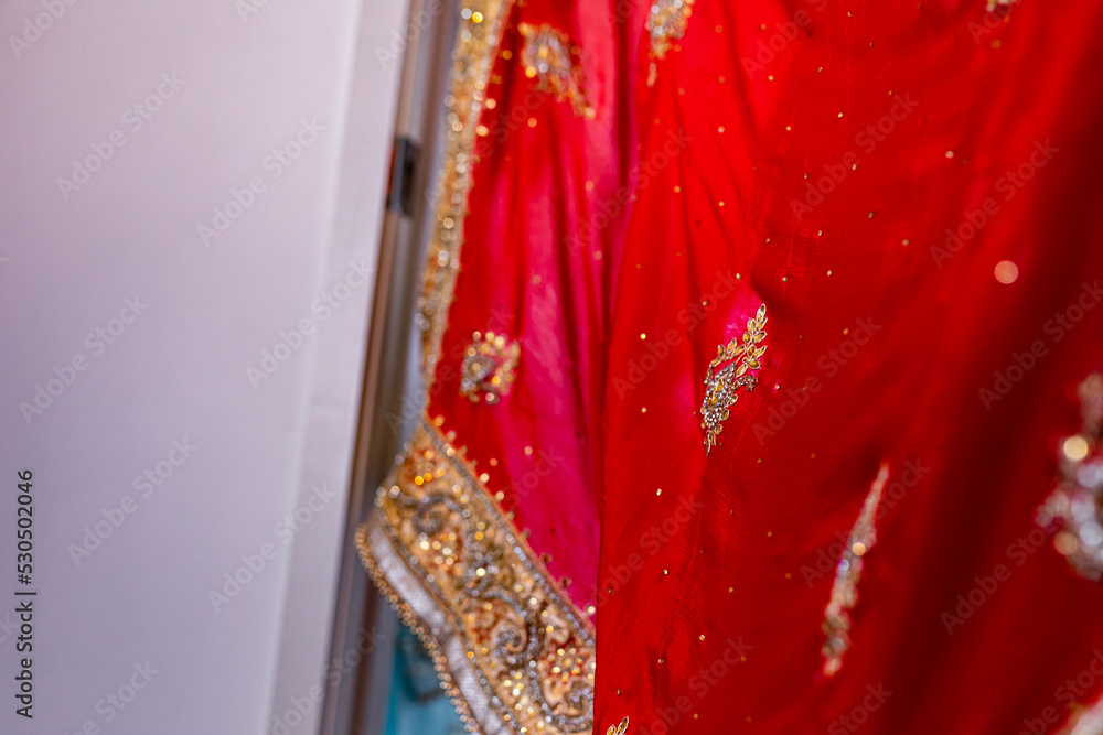Indian Punjabi bride's red wedding outfit veil, textile, fabric and pattern close up