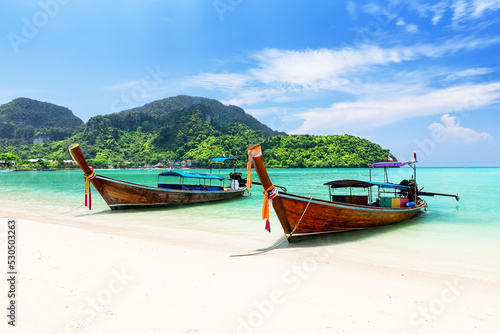Thai traditional wooden longtail boat and beautiful sand beach at Koh Phi Phi island in Krabi province, Thailand.